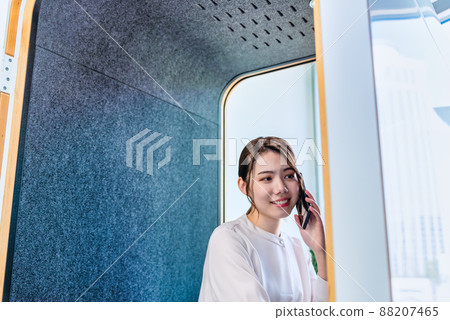 一位女士在免費地址辦公室的隔音電話亭打電話 一位女士在免費地址辦公室的隔音電話亭打電話 88207465