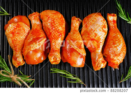 Convenience food, precooked.Raw Marinated chicken meat legs with spices for cooking for BBQ dark background. Top view.Copy space. Convenience food, precooked.Raw Marinated chicken meat legs with spices for cooking for BBQ dark background. Top view.Copy space. 88208207