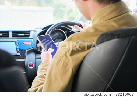 一個人在開車時操作智能手機 88210068