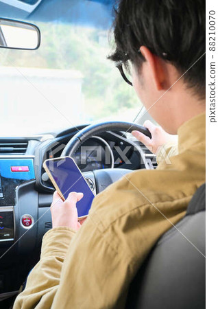 一個人在開車時操作智能手機 88210070