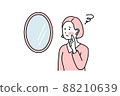 一個女人在鏡子裡檢查她的皮膚 88210639