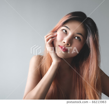 Naked Asian Woman with beauty skin portrait looking happy and playful isolated on gray for fashion and beauty concept. 88213963