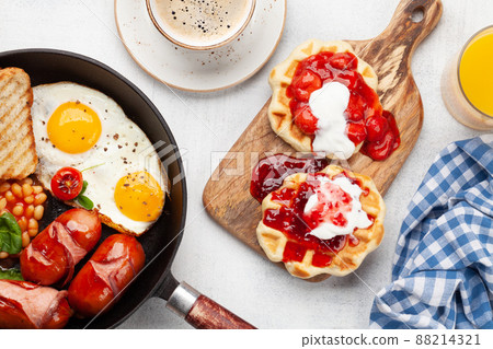 English breakfast with fried eggs, beans, bacon and sausages English breakfast with fried eggs, beans, bacon and sausages 88214321
