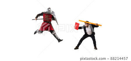 Creative collage. Fight between modern business man and medieval knight wearing armored clothes isolated on white background. Concept of eras comparison Creative collage. Fight between modern business man and medieval knight wearing armored clothes isolated on white background. Concept of eras comparison 88214457