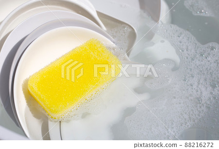 Dish washing, Dirty dishes soaking in kitchen sink. 88216272