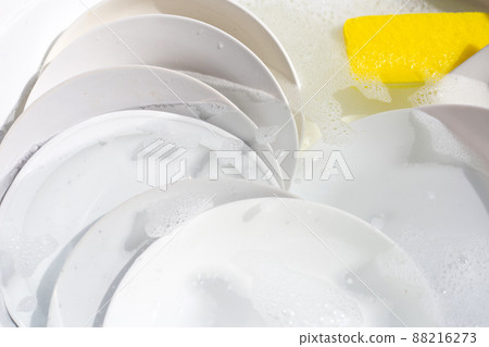 Dish washing, Dirty dishes soaking in kitchen sink. 88216273