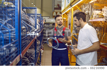 Seller in building materials store advises buyer on hoses for washing machines or dishwashers. Seller in building materials store advises buyer on hoses for washing machines or dishwashers. 88216990