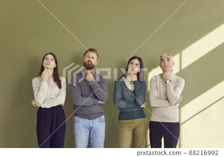 Portrait of group of people pondering or making decision while standing on green background. Portrait of group of people pondering or making decision while standing on green background. 88216992