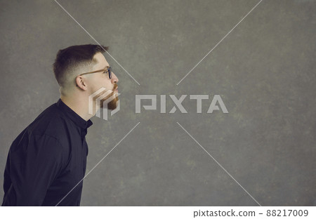 Side view of funny man pouting lips and kissing empty space on copy space background 88217009