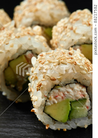 Traditional delicious fresh sushi roll set on a black background