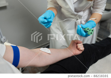 Beautician doctor's hands put test tube with blood in centrifuge container. Rejuvenation plasmolifting procedure. Beautician doctor's hands put test tube with blood in centrifuge container. Rejuvenation plasmolifting procedure. 88218101