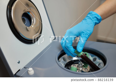 Beautician doctor's hands put test tube with blood in centrifuge container. Rejuvenation plasmolifting procedure. Beautician doctor's hands put test tube with blood in centrifuge container. Rejuvenation plasmolifting procedure. 88218139