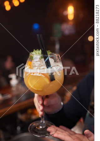 magnificent view of the crushed ice that is poured from the scoop into glass with cocktail on the bar. 88218273