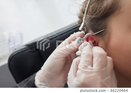Stretched lobe piercing, grunge concept. Pierced woman ear with black plug tunnel. industrial and rook. 88220464