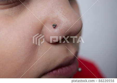 Professional holding the jewel of piercing day just before screw the ball. Tragus type. 88220558