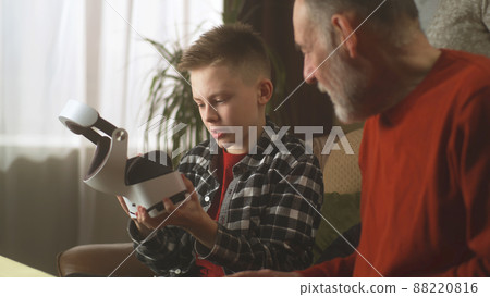 Grandchild showing virtual reality to grandfather 88220816
