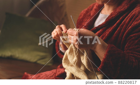 Crop elderly woman knitting on sofa 88220817
