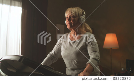 Aged woman running on a treadmill Aged woman running on a treadmill 88220873