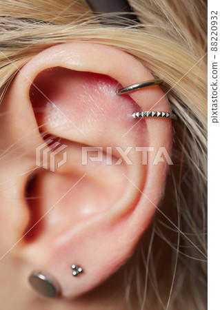 piercings on an ear. Conch and helix piercings close up. piercings on an ear. Conch and helix piercings close up. 88220932