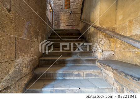 Old narrow stone staircase leading to stone bricks wall with closed window Old narrow stone staircase leading to stone bricks wall with closed window 88221841