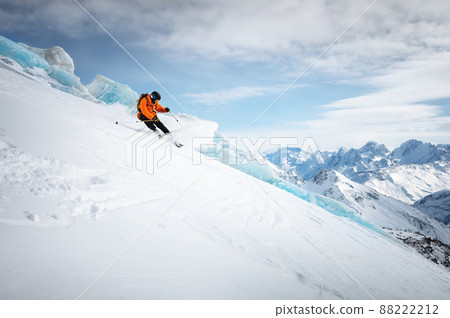 Professional skier ride at speed on a snowy slope against the backdrop of a glacier and high snow-capped mountains on a sunny day. Ski resort space copy presentation Professional skier ride at speed on a snowy slope against the backdrop of a glacier and high snow-capped mountains on a sunny day. Ski resort space copy presentation 88222212