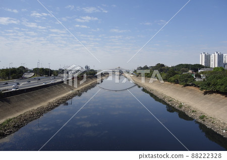dark waters of Tiete river reflecting the sky and bridge. Sao Paulo, Brazil 88222328