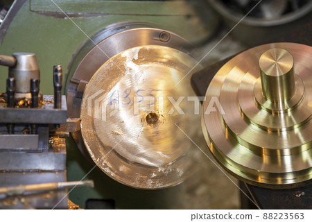 The abstract scene of lathe machine rough cutting the brass shaft parts. 88223563