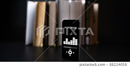 Audiobooks concept. Smartphone screen with audiobook application on paper books black background. Concept of education, library, students. Audiobooks concept. Smartphone screen with audiobook application on paper books black background. Concept of education, library, students. 88224058