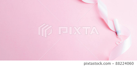 Menstrual tampon feminine hygiene. Pink ribbon with menstrual tampon on pink background. Menstruation feminine period. Sanitary hygiene concept. Medical healthcare gynecological banner. Menstrual tampon feminine hygiene. Pink ribbon with menstrual tampon on pink background. Menstruation feminine period. Sanitary hygiene concept. Medical healthcare gynecological banner. 88224060