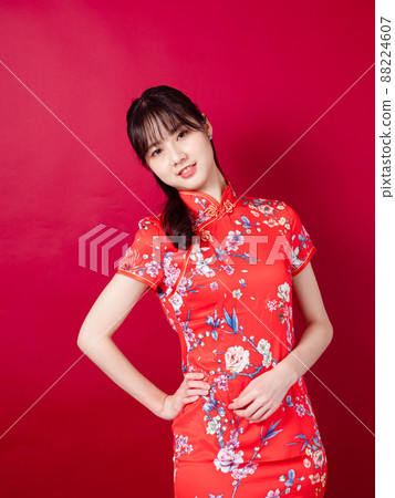 一個美麗的女人,帶著傳統的旗幟,紅色的背景。 一個美麗的女人,帶著傳統的旗幟,紅色的背景。 88224607