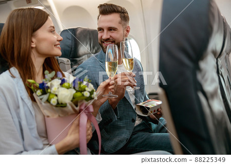 Happy couple toasting with champagne in passenger plane 88225349