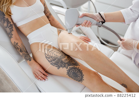 Young woman receiving laser treatment in cosmetology clinic Young woman receiving laser treatment in cosmetology clinic 88225412