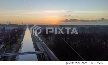 Beautiful sunrise or sunset with a colorful dramatic sky over a river with green bushes and color Beautiful sunrise or sunset with a colorful dramatic sky over a river with green bushes and color 88225425