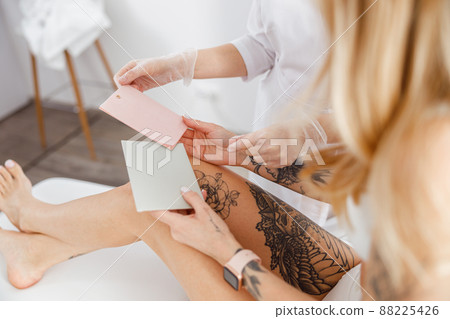 Beautician giving paper cards to woman in beauty salon 88225426