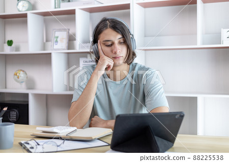 Young Asian man greets his friends and teachers in a live video with a smile on his face, Online communication , Stay home, New normal, VDO Call, Social distancing, Internet learning. 88225538