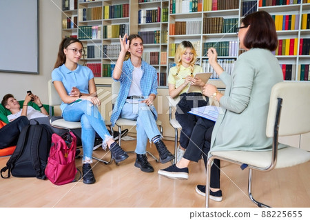 Group of teenage students with female teacher in library 88225655
