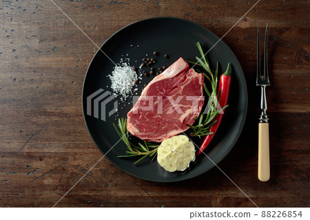 Raw beef steak with rosemary, garlic, salt, and pepper. Raw beef steak with rosemary, garlic, salt, and pepper. 88226854