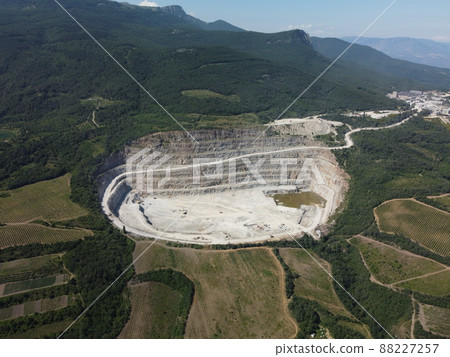 Aerial view industrial of opencast mining quarry with lots of machinery at work - crushed stone and building materials for the constractions industry. Oval mining industrial crater, acid mine drainage Aerial view industrial of opencast mining quarry with lots of machinery at work - crushed stone and building materials for the constractions industry. Oval mining industrial crater, acid mine drainage 88227257