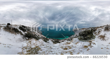 Snow covered rocky cliffs over sea. Winter sunset over the sea bay. Juniper tree under snow. Concept of winter holidays, travel, adventure and recreation Cape Fiolent in Balaklava, Sevastopol, Crimea. Snow covered rocky cliffs over sea. Winter sunset over the sea bay. Juniper tree under snow. Concept of winter holidays, travel, adventure and recreation Cape Fiolent in Balaklava, Sevastopol, Crimea. 88228530