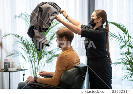 Long-haired hairdresser working with a male client at the beauty slaon Long-haired hairdresser working with a male client at the beauty slaon 88232514