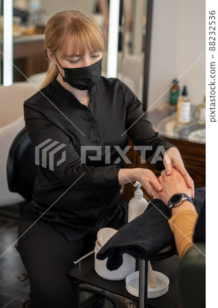 A beautician doing hands massage to the male client A beautician doing hands massage to the male client 88232536