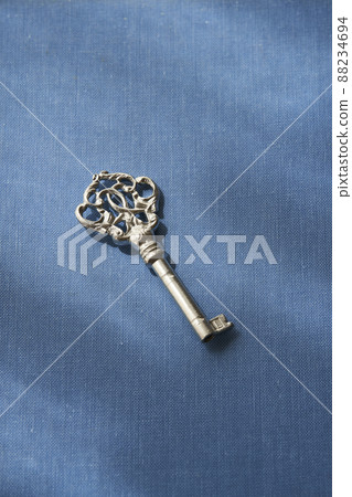 A silver key placed on an old book 88234694