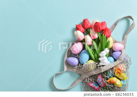 A beautiful bouquet of tulips with a string bag containing painted eggs 88236035