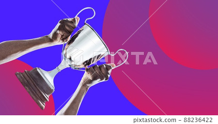 Digital composite image of african american player holding winning trophy over colored background Digital composite image of african american player holding winning trophy over colored background 88236422