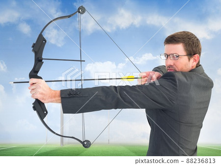 Composite image of caucasian businessman with bow and arrow against soccer field with copy space 88236813