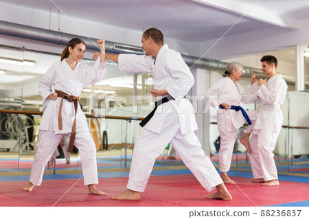 Man and woman in kimono sparring during group karate training 88236837