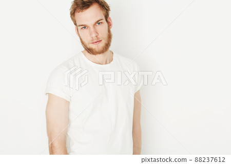 Cool and casual. Portrait of a young man wearing a white t-shirt. 88237612