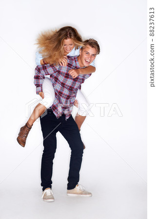 Enjoying life. Portrait of a male hipster giving a female hipster a piggyback ride. 88237613