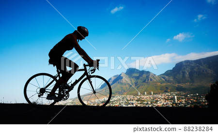 No view better. Silhouette shot of a young woman cycling against a beautiful scenic view. No view better. Silhouette shot of a young woman cycling against a beautiful scenic view. 88238284
