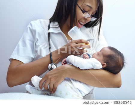Making a caring contribution to society. Shot of a healthcare worker giving formula to an infant who has a cleft palate. Making a caring contribution to society. Shot of a healthcare worker giving formula to an infant who has a cleft palate. 88238545